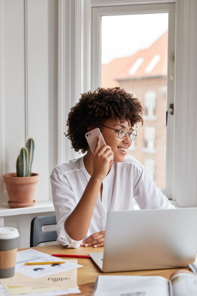 vertical-shot-of-cheerful-woman-bookkeeper-talks-o-VM8994S